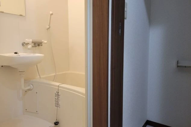 寮のランドリー。洗濯機とトイレが見える共用スペースが映る。