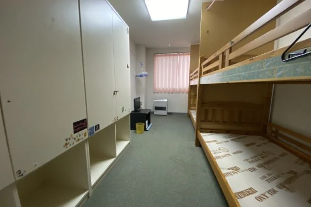 リゾートバイト相部屋寮の部屋の画像。TVと暖房器具がある。