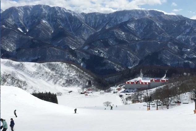 勤務先スキー場のゲレンデとホテル、そして雄大な雪山。