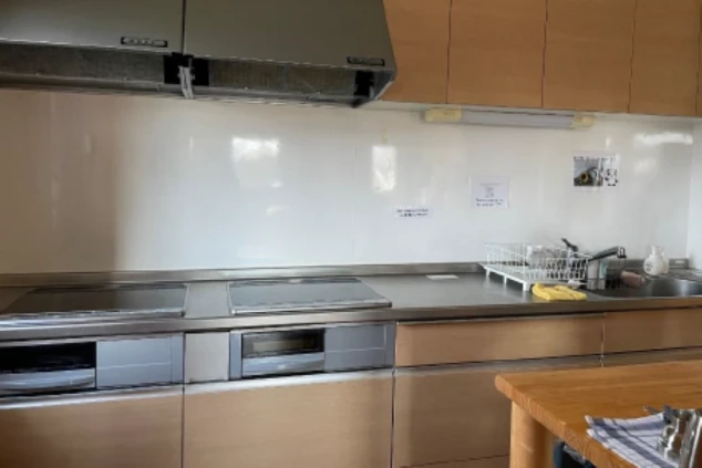 寮のキッチン。コンロが2口あり、調理台とシンクがある共用スペースが映る。