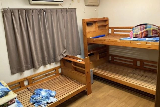 リゾートバイトの男性寮の相部屋。木製の二段ベッドとシングルベッドが置かれ、エアコンも完備されている。