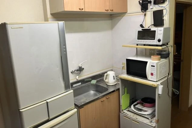 リゾートバイトの男性寮にある共用キッチン。冷蔵庫、電子レンジ、炊飯器、トースターなどの自炊用家電が揃っている。