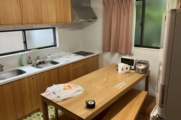 リゾートバイトの女性寮にある、広々とした共用キッチン。調理器具や家電、大きなダイニングテーブルが揃っており、自炊や食事に便利。