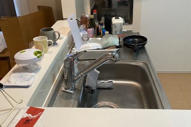 キッチンカウンターとシンクに並ぶ調理器具や食器。