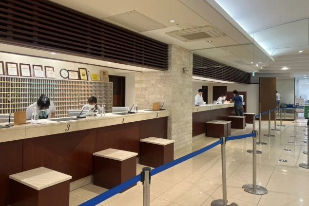 ホテルのフロントカウンターで、電話対応やチェックイン業務をするスタッフたち。リゾートバイトでホテルのフロント業務に興味がある方に、仕事の様子が伝わる画像。