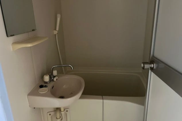 リゾートバイトの寮にある共用バスルーム。浴槽とシャワーが一体となった、清潔感のある設備の寮画像。