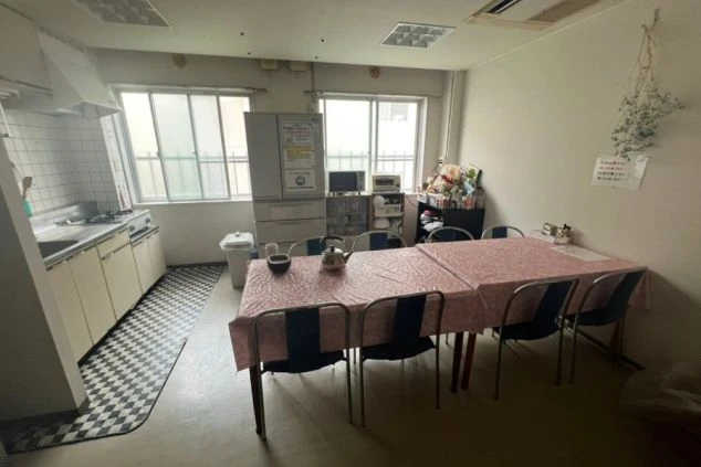 リゾートバイトの寮にある広々とした共用キッチンとダイニングスペース。冷蔵庫、電子レンジ、テーブルと椅子が備え付けられ、自炊や仲間との団らんを楽しめる画像の寮画像。