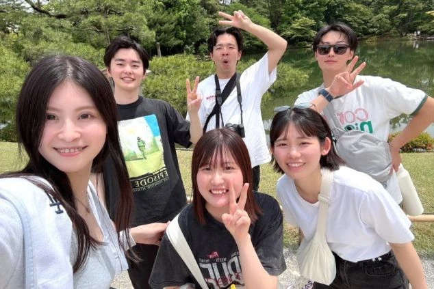 光地の公園で、笑顔でポーズをとる5人の男女。リゾートバイトで出会った仲間と、仕事の休日に観光を楽しんでいる様子を伝える、楽しそうなワクトリスタッフが撮影したオリジナル画像。