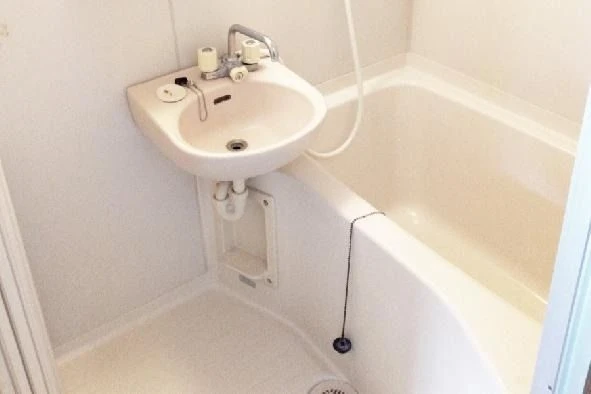 清潔感のあるユニットバス。洗面台と浴槽が一体となった寮のお風呂。