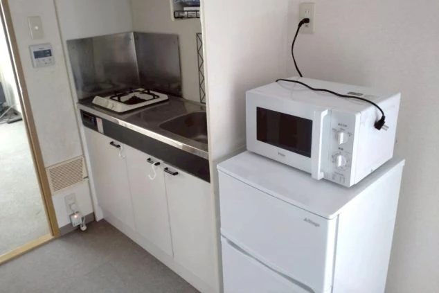 冷蔵庫、電子レンジ、ガスコンロが付いた、自炊可能なミニキッチン。
