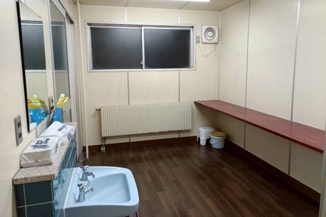 リゾートバイトの寮の共用キッチンの画像。シンクと電子レンジ、自動販売機が並び、共同生活の場として利用できる。