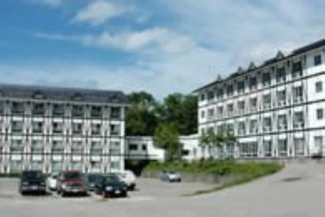 寮の外観。アルプス風の建物が2棟並び、手前に駐車場が映る。