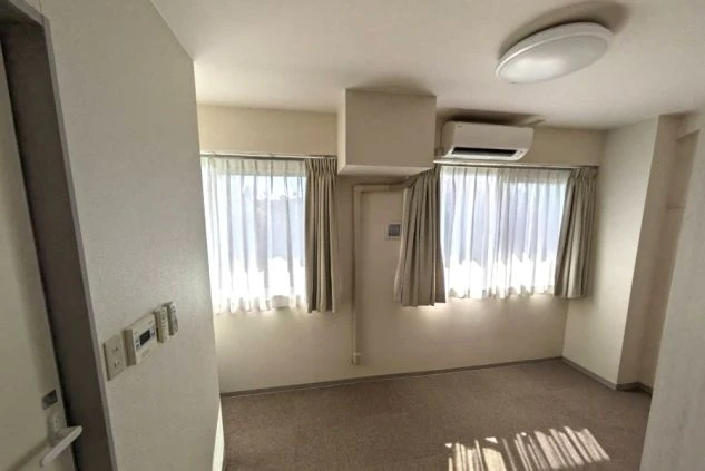 寮の個室。窓が2つあり、エアコンも完備された明るく清潔な部屋。