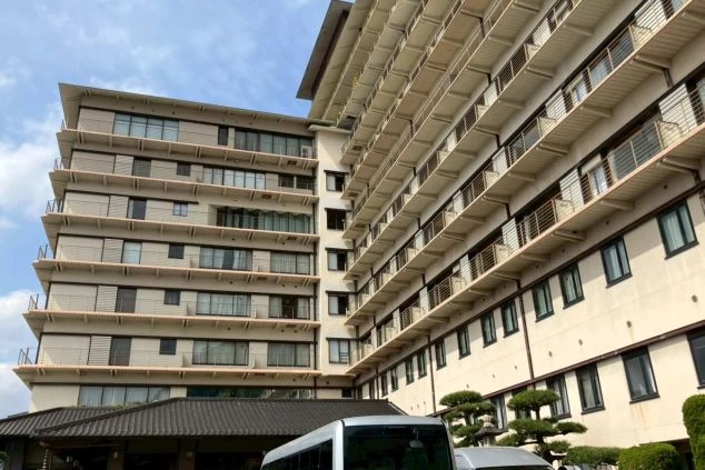 多くのバルコニーが並ぶ、海沿いに建つ大規模な温泉旅館の外観の画像。