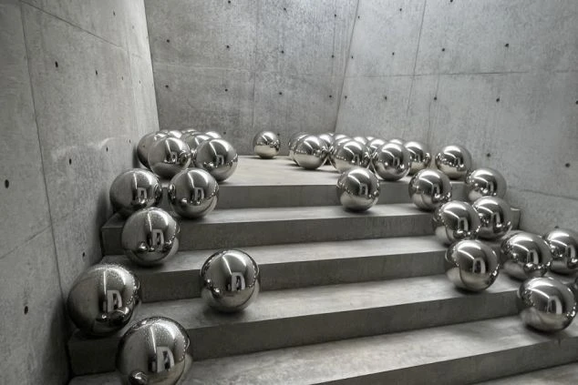 コンクリートの階段に鏡面の球体が並ぶ、美術館の現代アート作品が映るイメージ画像。リゾートバイトの休日を満喫。