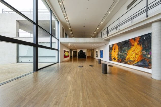  広々とした現代美術館の内部。大きな絵画やアート作品が並び、大きな窓から光が差し込むイメージ画像。リゾートバイトの休日を満喫。