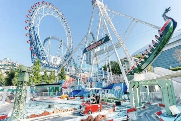 青空の下、遊園地のアトラクション「観覧車」や「バイキング」が写る風景。リゾートバイトでアミューズメント施設やテーマパークでの仕事に興味がある方に訴求する画像。