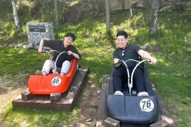 自然の中でゴーカートを楽しむ2人の男性。リゾートバイトの休日には、仕事の疲れを癒やしながらアクティビティを楽しめることを示すワクトリスタッフが撮影したオリジナル画像。