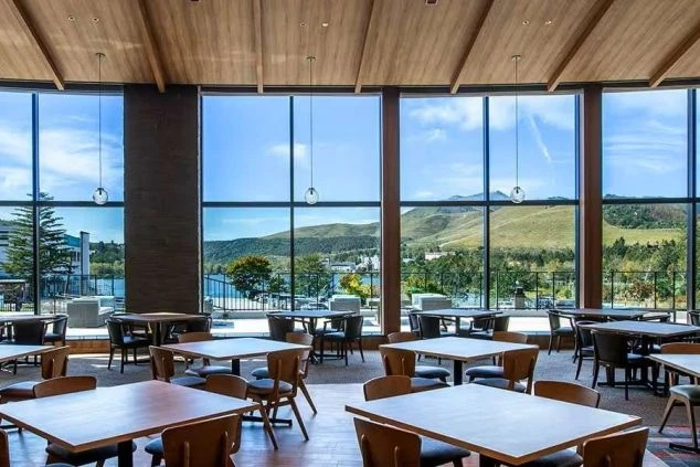 大きな窓から白樺湖と緑の山々が一望できる、広々としたレストラン。リゾートバイトでホテルレストランのホールや調理スタッフとして働きたい方に魅力的な職場環境の画像。