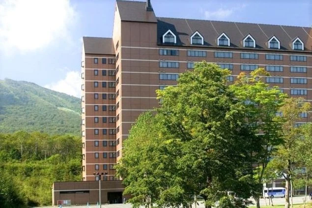 広大な山の中にある大規模リゾートホテルの外観。ゲレンデも見えるこのホテルの外観は、リゾートバイトの勤務地としての規模や雰囲気を伝える画像です。