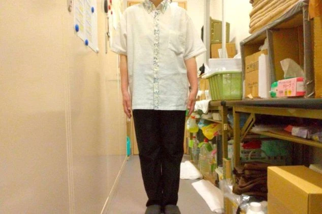 白いシャツと黒いパンツを着用した、リゾートバイトの制服。旅館やホテルでの大浴場清掃や洗い場の仕事に興味がある方に訴求する画像。