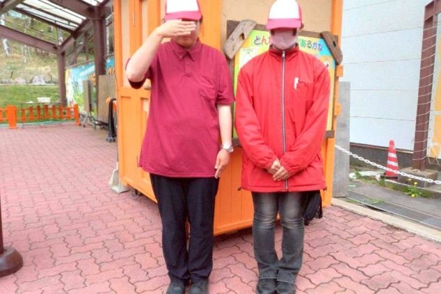 赤いポロシャツと赤いジャンパーを着た2人の人物。リゾートバイトでレジャー施設やテーマパークのスタッフとして働く際の制服のイメージが伝わる画像。