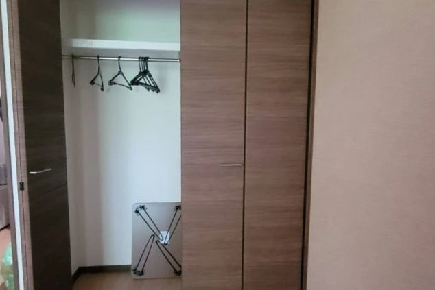 寮の個室。ハンガーラックと折りたたみ机が入ったクローゼットが映る。