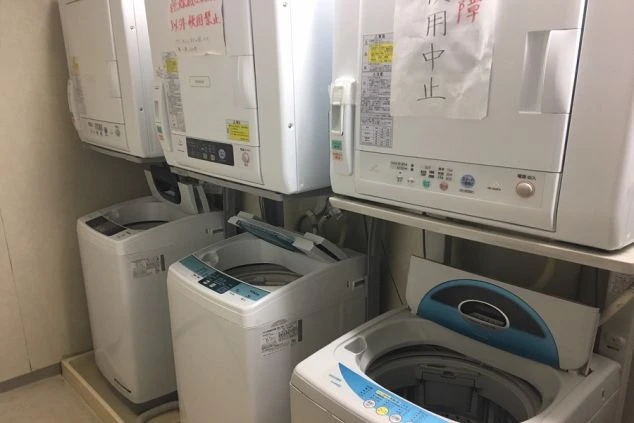リゾートバイトの相部屋寮の共用洗濯機・乾燥機の画像。