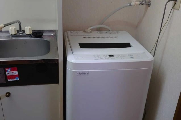 個室寮内に完備された室内洗濯機。共同利用の必要がなく、長期滞在や連勤時もすぐに洗濯できる便利な設備。