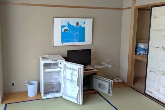 リゾートバイトの相部屋寮、和室の部屋内にある設備の画像。冷蔵庫・金庫・テレビ・押し入れがあります。