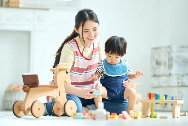 子供と女性が積み木で遊んでいる画像。リゾートバイトにおける託児所やキッズルームの仕事のイメージ。