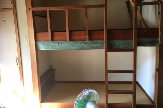 リゾートバイトの寮の、木製二段ベッド。プライベートな寝室スペースとして、ゆっくり休むことができます。