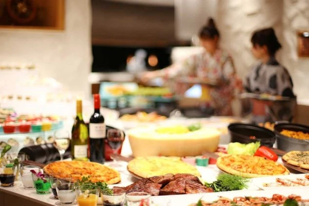 ピザやローストビーフ、チーズなどが並ぶ、ホテルの豪華なビュッフェ。リゾートバイトでは、こうしたレストランでの接客や調理補助の仕事もあります。