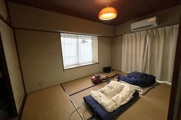 リゾートバイトのカップル寮の和室。布団が敷かれ、テレビや掃除機も備え付けられた、広々とした部屋の画像。