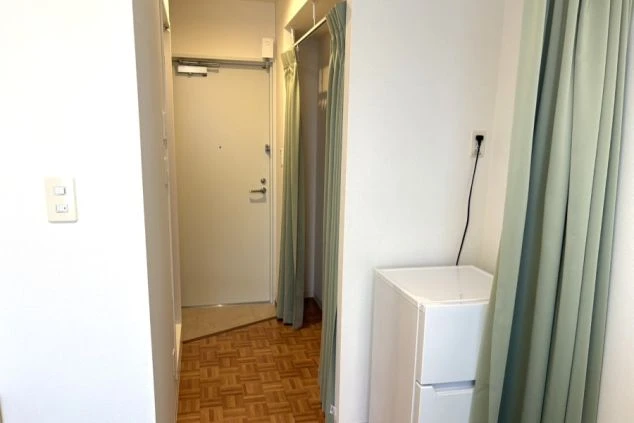 箱根強羅の旅館でリゾートバイトするスタッフが住む寮の個室の入口や冷蔵庫の画像。