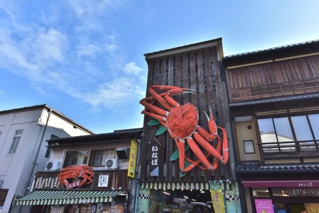 大きなカニのオブジェが飾られた海鮮料理店の建物。リゾートバイトで、カニ料理を提供する飲食店や土産物店での接客に興味がある方に訴求する画像。