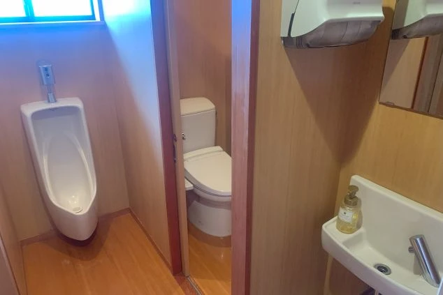 リゾートバイトの個室寮にある、男性用のトイレと洗面台。清潔感のある、プライベートな設備の画像。