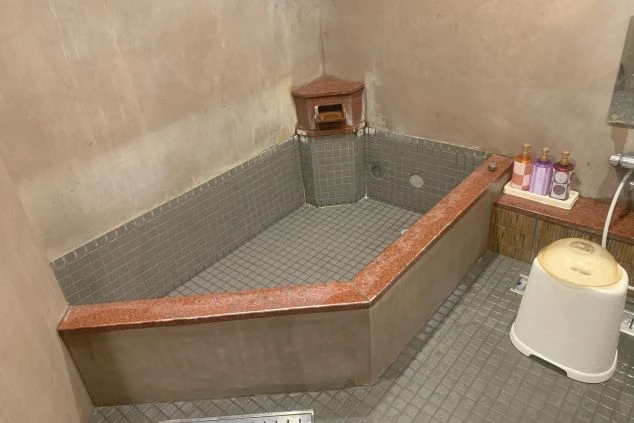 リゾートバイトの個室寮にある浴室。水色の壁と白いタイルが特徴的で、シャワーや浴槽が備え付けられた設備の画像。