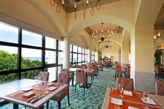 大きな窓からオーシャンビューが楽しめる、高級感のあるレストラン。アーチ型の天井と上品なシャンデリアが、特別な食事の時間を演出します。