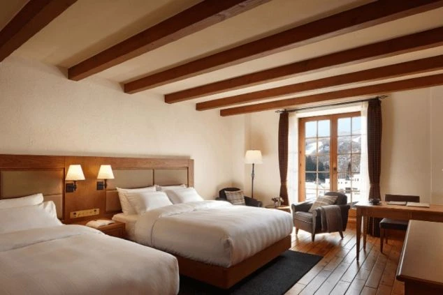 ホテルの客室。ベッドが2台並び、窓から雪景色が見える快適な部屋が映る職場のイメージ画像。