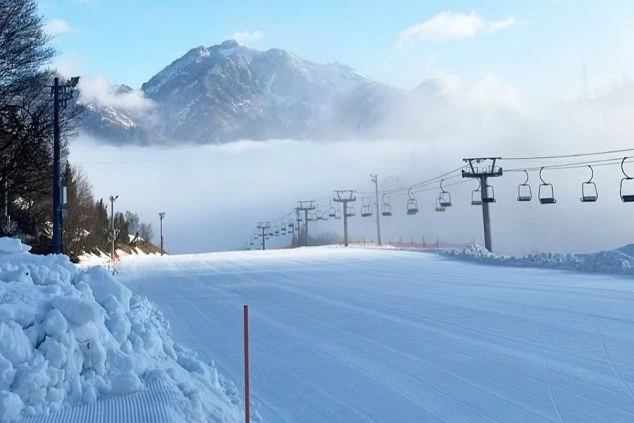 雲海が広がる眼下に、手入れされたゲレンデとリフトが並ぶスキー場の写真。雲の上で滑っているかのような、リゾートバイトだからこそ見られる非日常的な絶景を伝えます。