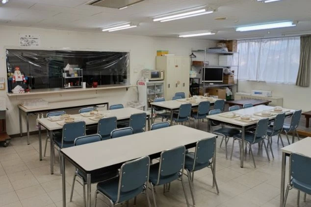 スタッフ用食堂の画像。広々としたテーブル席が並び、電子レンジや冷蔵庫も完備された、食事や休憩に利用できる清潔な共有スペース。