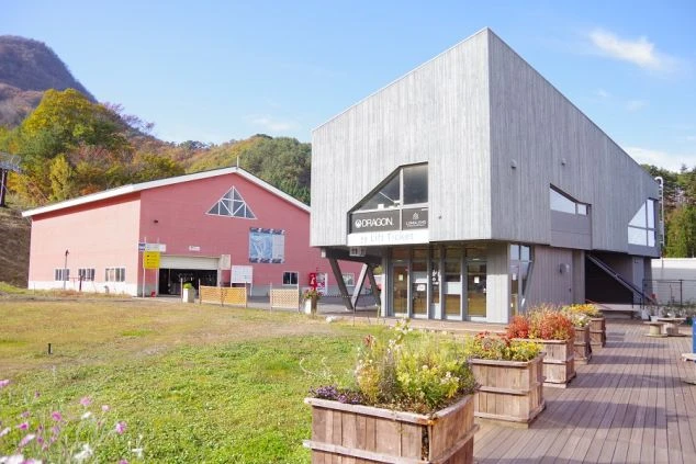 レンタルショップで、お客さんにスノーボードのレンタル品を説明しているスタッフ。