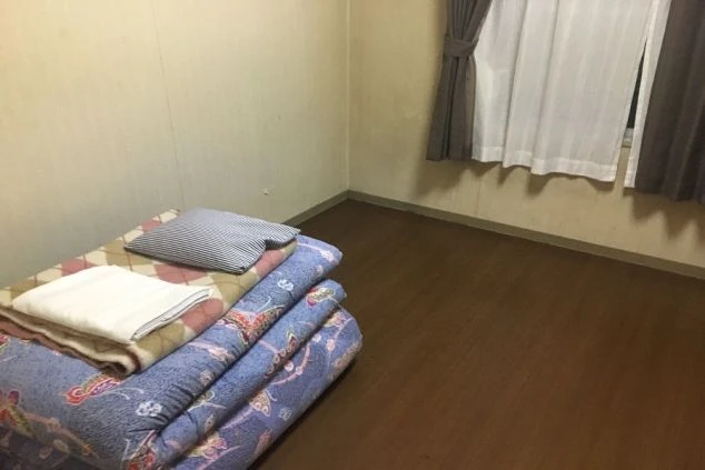 リゾートバイトの相部屋寮の部屋の画像。寝具が置いてある。