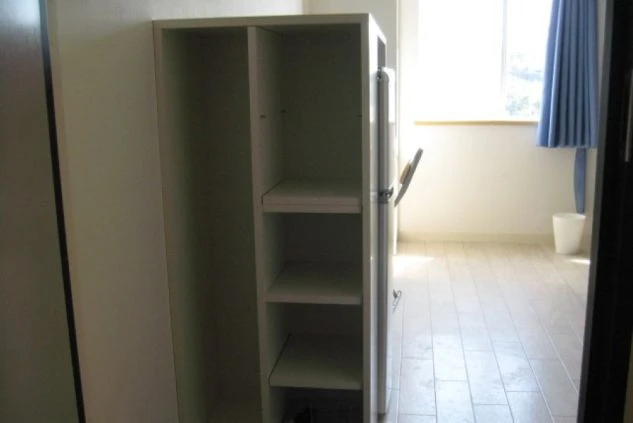 リゾートバイトの寮の部屋の収納棚の画像。棚が開いており、内部には収納スペースが見える。荷物を整理できる設備が備わっている。