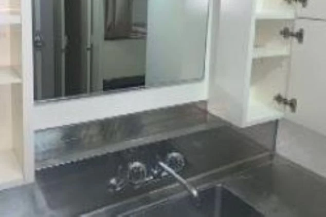 リゾートバイトの寮にある洗面所。鏡、シンク、収納棚が備え付けられています。