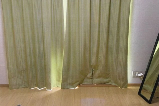 リゾートバイトの寮の個室。フローリングの部屋で、カーテンの向こうにはベランダがあります。