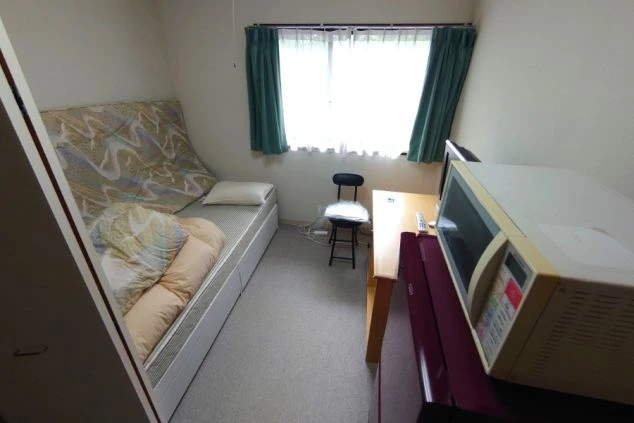 リゾートバイトの個室寮の部屋の画像。ベッド・机・TV・冷蔵庫・電子レンジが見える。