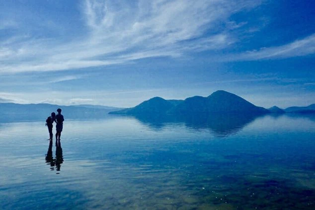 モダンな建物外観。ベージュと濃い色のラインが入った多層階のホテル棟と、エントランス部分のサイン。