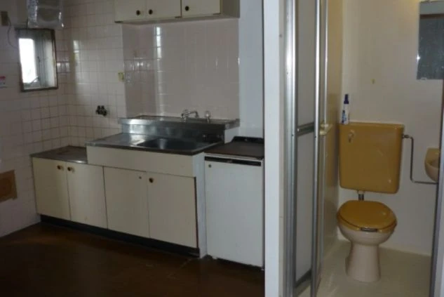 リゾートバイトの相部屋寮のキッチンとユニットバスの画像。